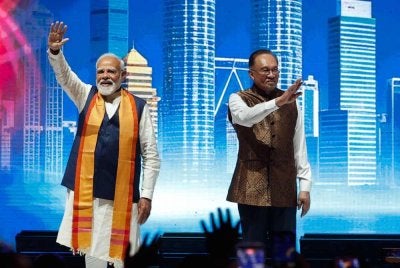 Anwar (kanan) dan Modi (kiri), melambai kepada masyarakat India dari atas pentas semasa Program Komuniti India di MIECC pada Sabtu. Foto Bernama