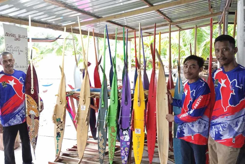 Mohd Farid (kanan) bersama Nur Ikram (tengah) dan Abdul Rahman menunjukkan jong yang dipamerkan di Galeri Jong Serkat.