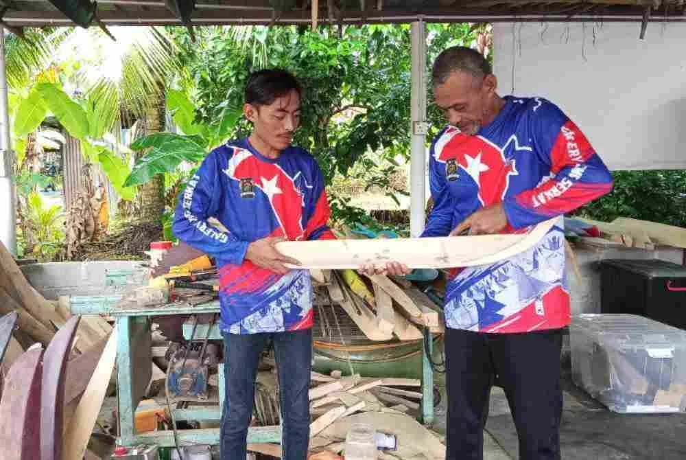 Nur Ikram (kiri) membantu ayahnya Abdul Rahman membuat jong di Galeri Jong Serkat.