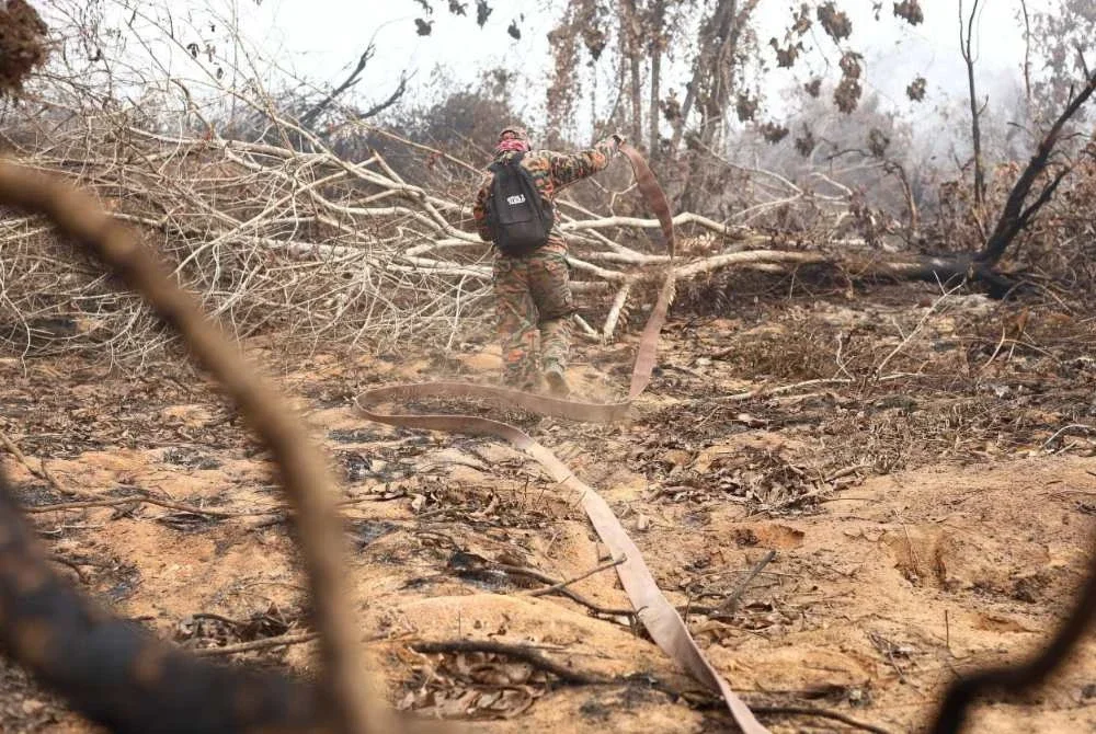 Anggota bomba memadam kebakaran tanah gambut di Batu 13/14, Air Itam, Muar. Foto: JBPM Johor