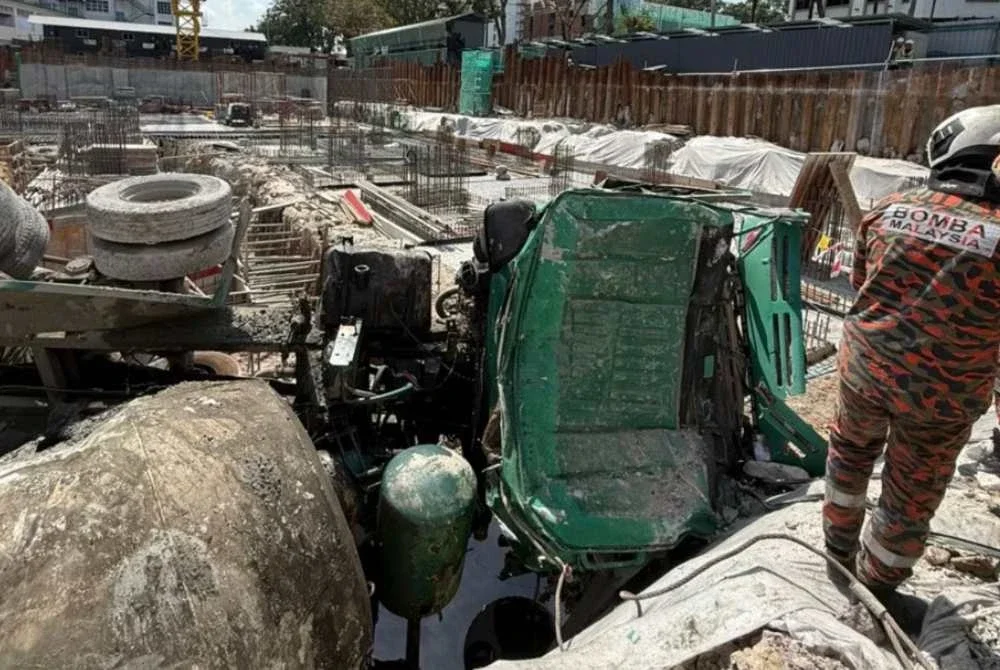 Lori simen berkenaan dipercayai hilang kawalan lalu terjatuh ke dalam terbalik ke dalam kawasan pembinaan 'basement' ketika kerja pembekalan konkrit. Foto: JBPM Pulau Pinang