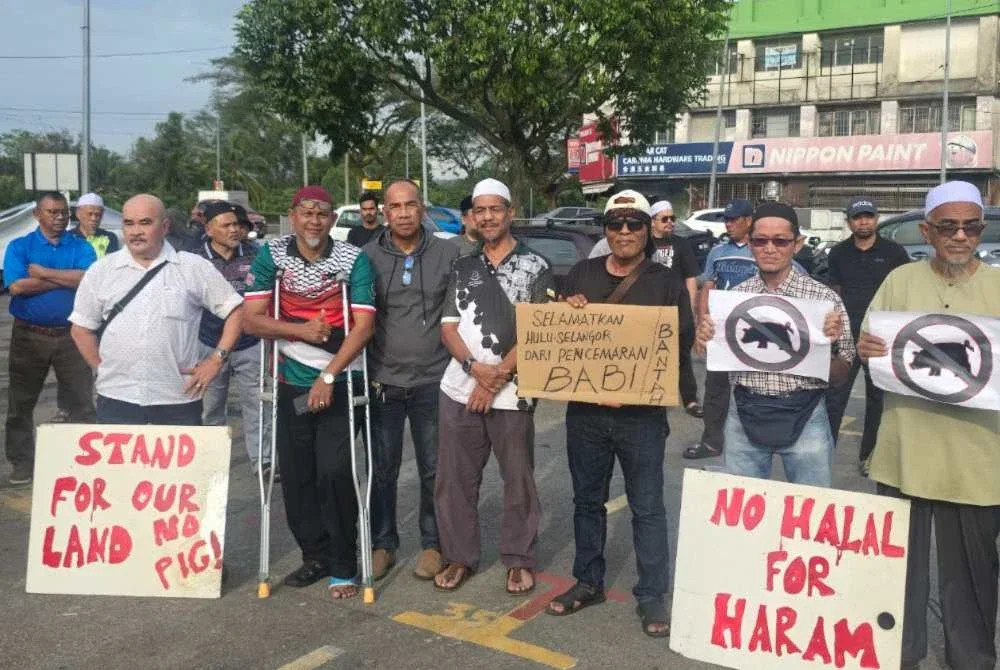 Penduduk memegang sepanduk bagi menuntut kerajaan Selangor membatalkan sepenuhnya cadangan pemindahan ladang babi dari Tanjung Sepat ke Bukit Tagar.