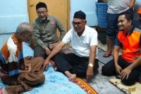 Ismail (kiri) semasa menerima kunjungan Zamakhshari (tiga, kanan) serta JKM Pasir Mas di rumahnya di Kampung Repek, Pasir Mas pada Ahad.
