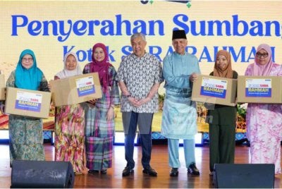 Ahmad Zahid (empat dari kanan) bersama Menteri Perladangan dan Komoditi, Datuk Seri Dr Noraini Ahmad (tiga dari kiri) dan Ameer Ali (tiga dari kanan) bergambar bersama penerima kotak SARA Rahmah. Foto SINAR HARIAN / MOHD HALIM ABDUL WAHID