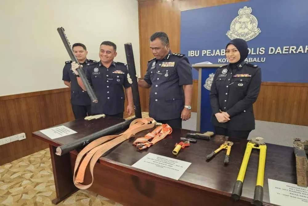 Kasim (tiga dari kanan) menunjukkan antara peralatan digunakan untuk melakukan kegiatan curi kabel di Kota Kinabalu.