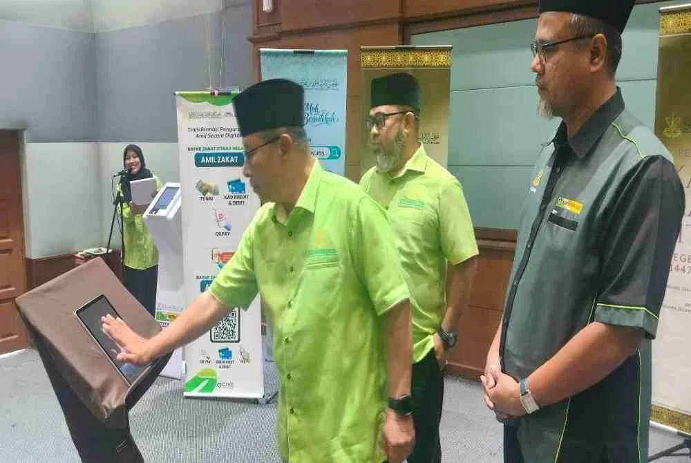 Ahmad Hairi diiringi Dr Asmadi (kiri) dan Timbalan Pengurus Besar Pusat Kutipan Zakat Pahang, Che Samsol Ibrahim menyempurnakan gimik pelancaran Sistem e-Derma dan Sistem Moh Bersedekah, pada Isnin.