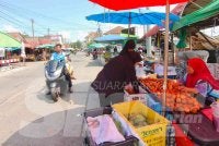 Kamariah (kanan) sedang melayan pelanggan di gerai buahnya di Tak Bai, Narathiwat. Foto:SINAR HARIAN/HAZELEN LIANA KAMARUDIN
