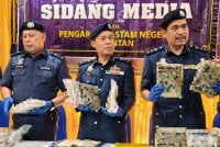Ishak (tengah) menunjukkan ganja mampat yang dirampas JKDM Kelantan semasa sidang akhbar di Cawangan Penguat kuasa JKDM Pengkalan Kubor, Tumpat pada Isnin. Foto Sinar Harian/Hazelen Liana Kamarudin 