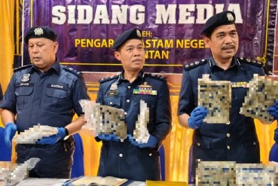 Ishak (tengah) menunjukkan ganja mampat yang dirampas JKDM Kelantan semasa sidang akhbar di Cawangan Penguat kuasa JKDM Pengkalan Kubor, Tumpat pada Isnin. Foto Sinar Harian/Hazelen Liana Kamarudin 