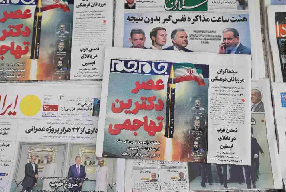 Akhbar harian Iran memaparkan laporan pusingan pertama rundingan antara Iran dan Amerika Syarikat di sebuah kios di Teheran.
