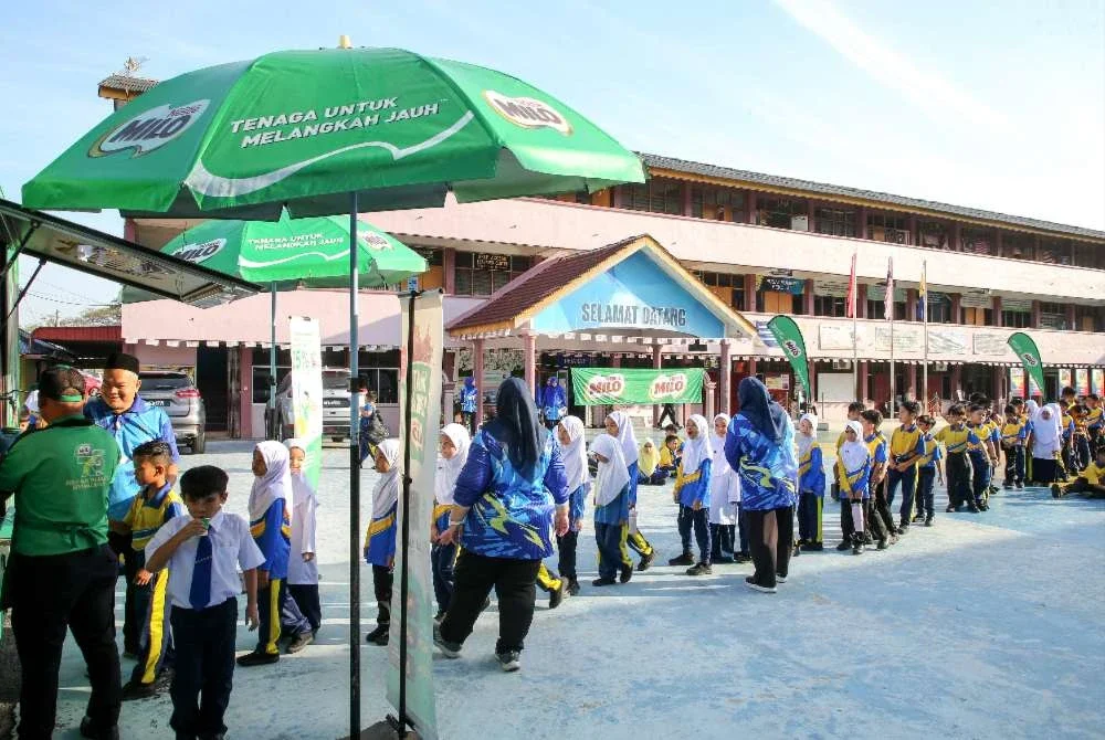 Murid beratur untuk mendapatkan minuman MILO.