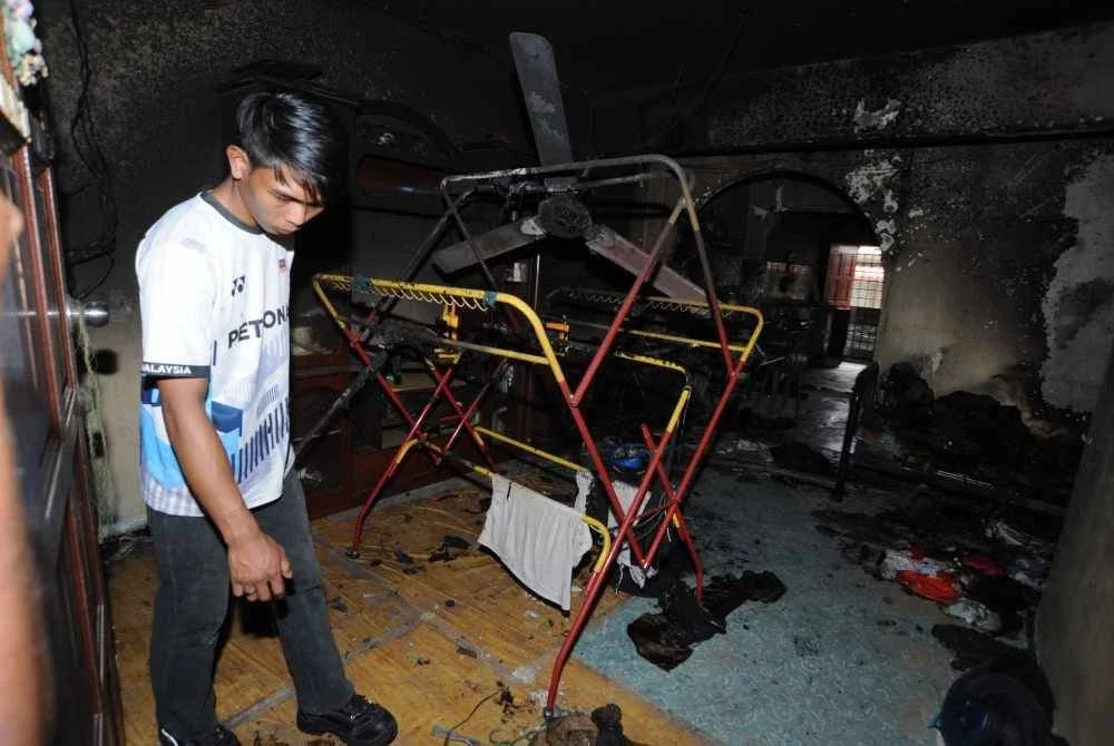 Irfan melihat keadaan sekitar rumah yang musnah terbakar di Taman Damai Jaya Skudai.