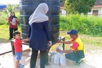 Penduduk mendapatkan bekalan air di tangki statik di Kampung Parit Panjang, Ayer Baloi, Pontian.
