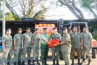 Fng Ah Seng (tengah) mengagihkan limau kepada askar wataniah.