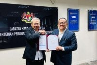 Mohd Zaki (kanan) menerima dokumen yang ditandatangani Mohd Fadzli di Putrajaya pada Isnin.