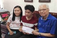 Ismail Sabri (kanan) menyantuni Loke Kim Yen (kiri) ketika menyerahkan bantuan Tahun Baharu Cina.