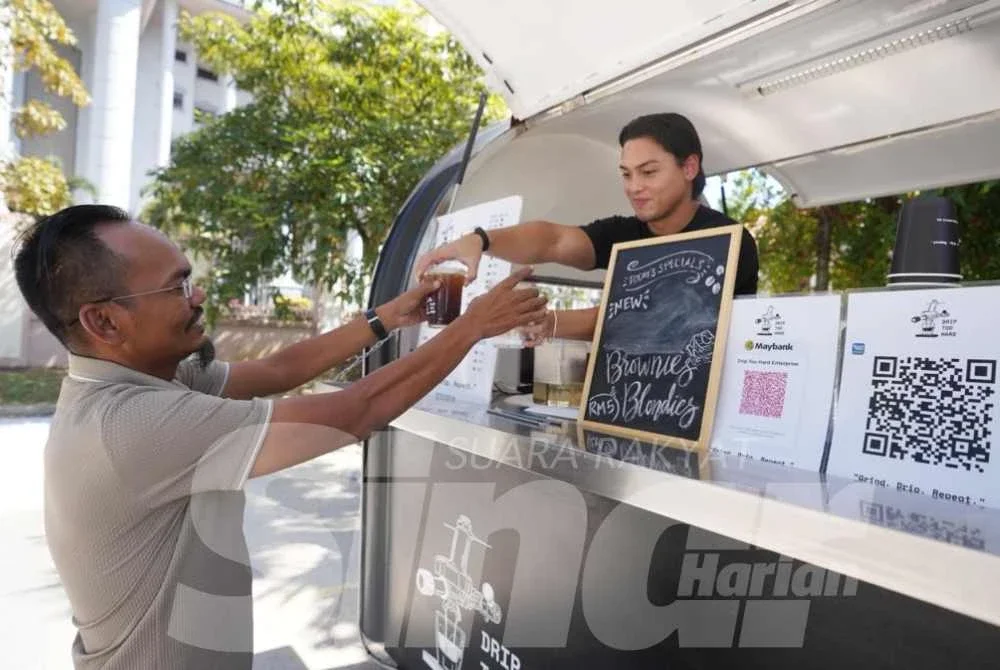 Pelanggan mendapatkan minuman di treler kopi Drip Too Hard yang menjadi pilihan warga kerja sekitar Kompleks Mahkamah Kuala Lumpur.