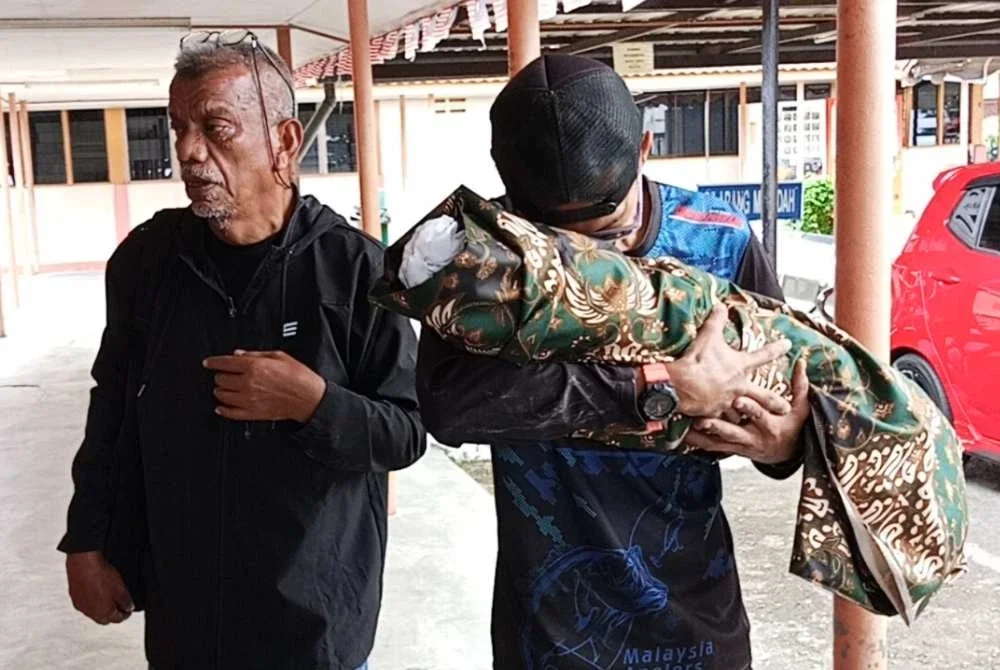 Muhamad Asyraf tidak dapat menahan sebak mengucup jenazah anaknya yang maut dalam nahas di Jalan Sungai Rengit- Kota Tinggi pada Selasa.