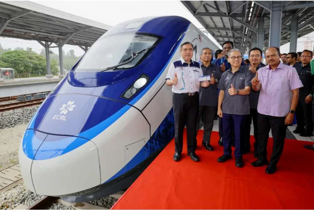 Loke dan Menteri Komunikasi, Datuk Fahmi Fadzil bergambar selepas perasmian tren elektrik pelbagai gerabak (EMU) dan lokomotif elektrik (E-Loco) di Stesen ECRL KotaSAS pada Rabu. - Bernama
