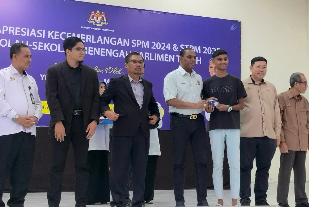 Saravanan (tengah) menyampaikan sumbangan kepada penerima sempena Majlis Apresiasi Kecemerlangan SPM 2024, STPM2025 dan Dermasiswa IPTA/IPTS Parlimen Tapah di Dewan Merdeka, Tapah pada Rabu.