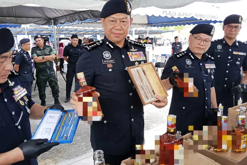 Ab Rahaman menunjukkan arak tiruan yang dirampas ketika sidang akhbar di Balai Polis Senai, Kulai pada Rabu.