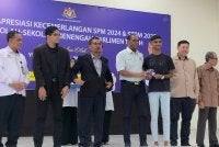 Saravanan (tengah) menyampaikan sumbangan kepada penerima sempena Majlis Apresiasi Kecemerlangan SPM 2024, STPM2025 dan Dermasiswa IPTA/IPTS Parlimen Tapah di Dewan Merdeka, Tapah pada Rabu.