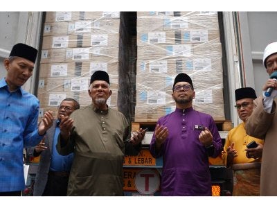 Menteri Di Jabatan Perdana Menteri (Hal-ehwal Agama), Senator Dr. Zulkifli Hassan (tiga, kiri) dan Pengerusi Eksekutif Yayasan Restu, Datuk Dr. Abdul Latiff Mirasa (dua, kiri) mengaminkan doa di hadapan konten berisi naskah Al-Quran yang bakal dihantar ke tiga buah negara.