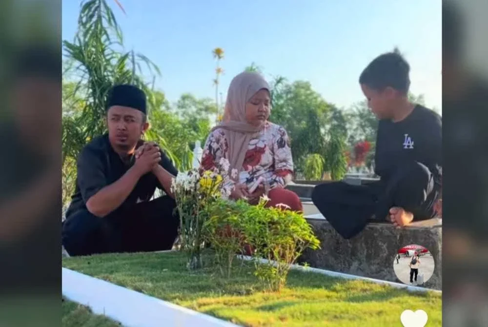 Dzulfikar (kiri) menziarahi pusara arwah isterinya bersama dua anaknya.