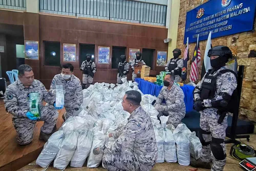 Mazlan (kiri) menunjukkan 76 guni mengandungi bahan disyaki syabu dengan anggaran berat keseluruhan 1.572 tan pada sidang akhbar di Ibu Pejabat Maritim Negeri Pahang, Kuantan pada Khamis.