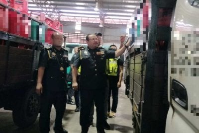 Mohd Hazimin (kanan) menunjukkan lori serta LPG yang disita menerusi serbuan dijalankan pada Rabu.