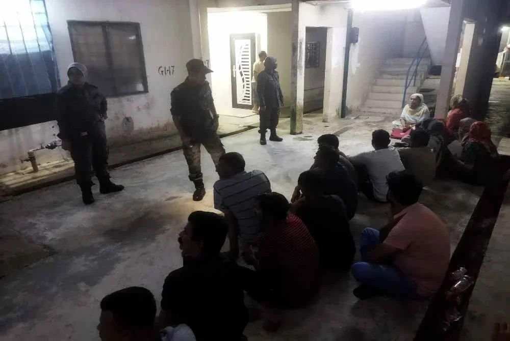 Antara warga asing yang ditahan dalam serbuan di Apartmen Seri Semarak, Bukit Beruntung pada Khamis.
