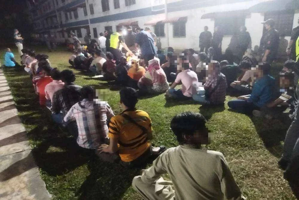 Antara warga asing yang ditahan dalam serbuan di Apartmen Seri Semarak, Bukit Beruntung pada Khamis.
