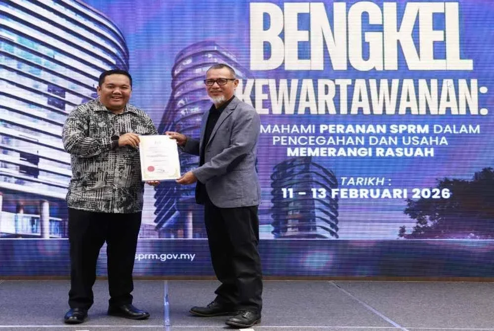 Ahmad Rosli (kanan) menerima sijil penghargaaan daripada Pengarah Bahagian Komunikasi Strategik SPRM, Hisyam Mohd Yusoff semasa Bengkel Kewartawanan SPRM 2026 di Genting Highlands pada Khamis. Foto: SPRM