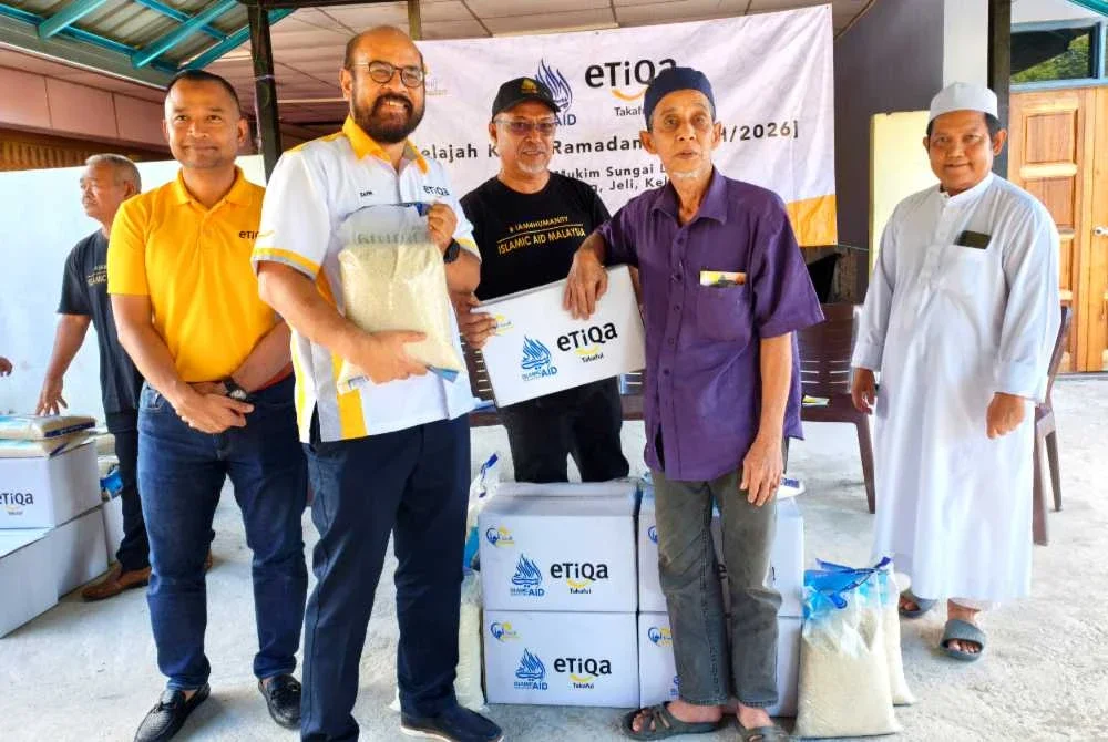 Zafri (dua dari kiri) dan Zawahir (tiga dari kanan) menyampaikan sumbangan kepada penerima pada Jelajah Kasih Ramadan IAM dan Etiqa Takaful yang diadakan di Masjid Mukim Sungai Long, Batu Melintang, Jeli pada Jumaat. Foto Sinar Harian/ Hazelen Liana Kamarudin