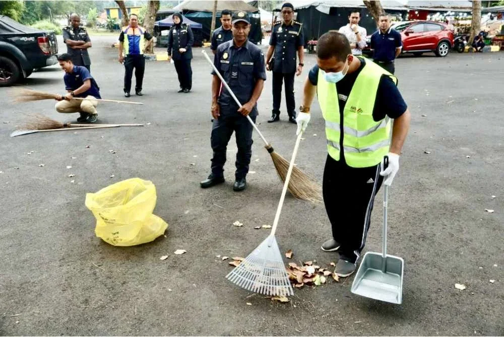 Pegawai Penguatkuasa SWCorp Pahang memantau salah seorang pesalah menjalani PKM di Jalan Lurah Semantan, Temerloh pada Jumaat. Foto SWCorp Pahang