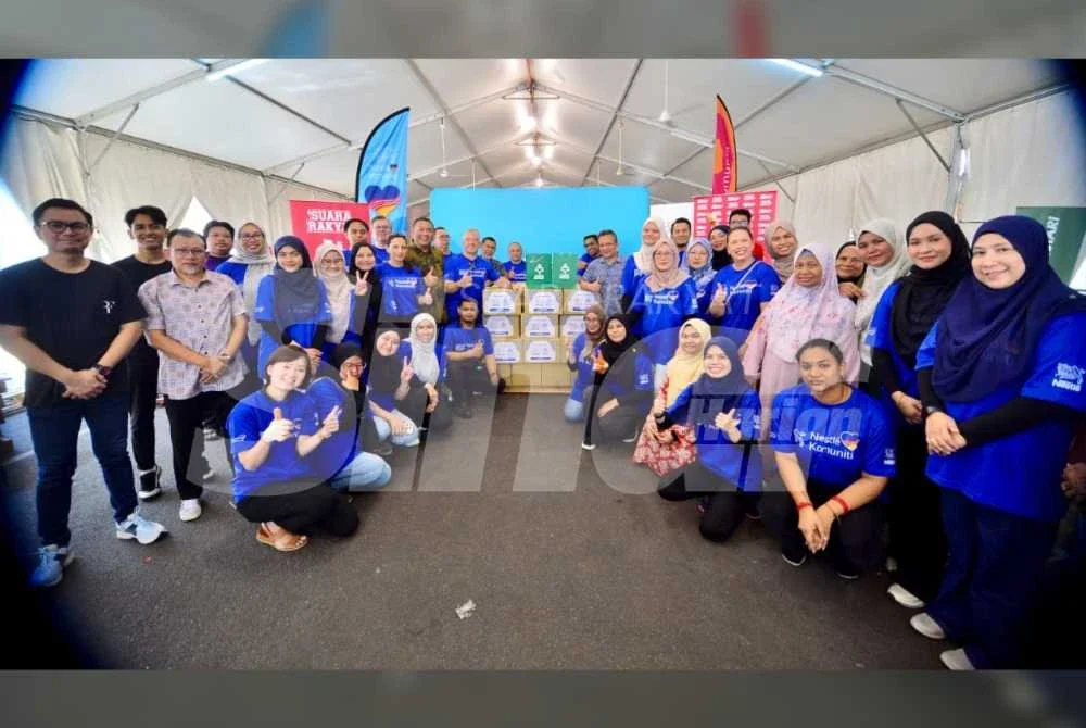 Sukarelawan terlbat dalam melaksanakan kerja pembungkusan bergambar bersama pegawai kanan Nestle dan Karangkraf. Foto: Asril Aswandi Mohd Syukur