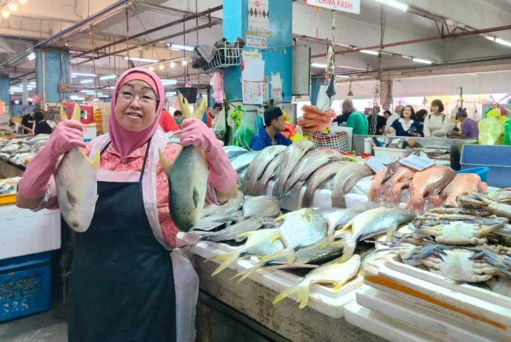 Roshni menunjukkan ikan bawal emas yang dijual di gerainya di Pasar Besar Ipoh di sini pada Jumaat.