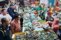 Kah Leong (dua dari kiri) ketika meninjau jualan ikan sempena Majlis Peluncuran dan Sesi Walkabout Skim Harga Maksimum Musim Perayaan Tahun Baharu Cina 2026 di Pasar Besar Ipoh di sini pada Jumaat.