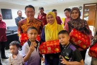 Kor Ming (tiga dari kanan) turut mengagihkan 500 kotak limau mandarin kepada warga kementerian bagi menyuntik keceriaan dan mengeratkan lagi silaturahim sesama warga kerja dalam melaksanakan amanah kepada rakyat.