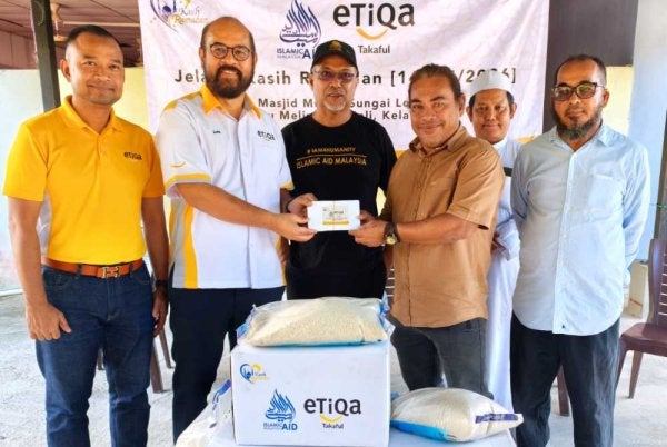 Zawahir (tiga dari kiri) dan Zafri (dua dari kiri) menyampaikan sumbangan kepada bekas pengamal media di Kelantan pada Jelajah Kasih Ramadan IAM dan Etiqa Takaful yang diadakan di Masjid Mukim Sungai Long, Batu Melintang, Jeli pada Jumaat.Foto Sinar Harian/Hazelen Liana Kamarudin