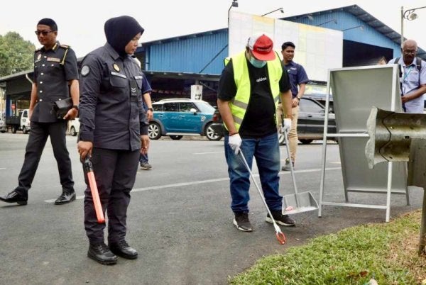 Salah seorang pesalah melaksanakan kerja-kerja pembersihan termasuk menyapu, mengutip sampah dan membersihkan longkang di kawasan awam di Jalan Lembah Semantan, Temerloh pada Jumaat. Foto SWCorp Pahang