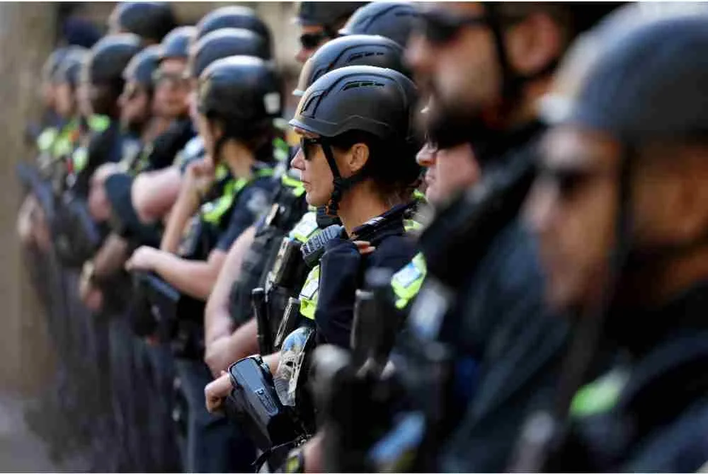 Polis berdiri dalam barisan semasa penunjuk perasaan berarak ketika lawatan Presiden Israel di Melbourne.