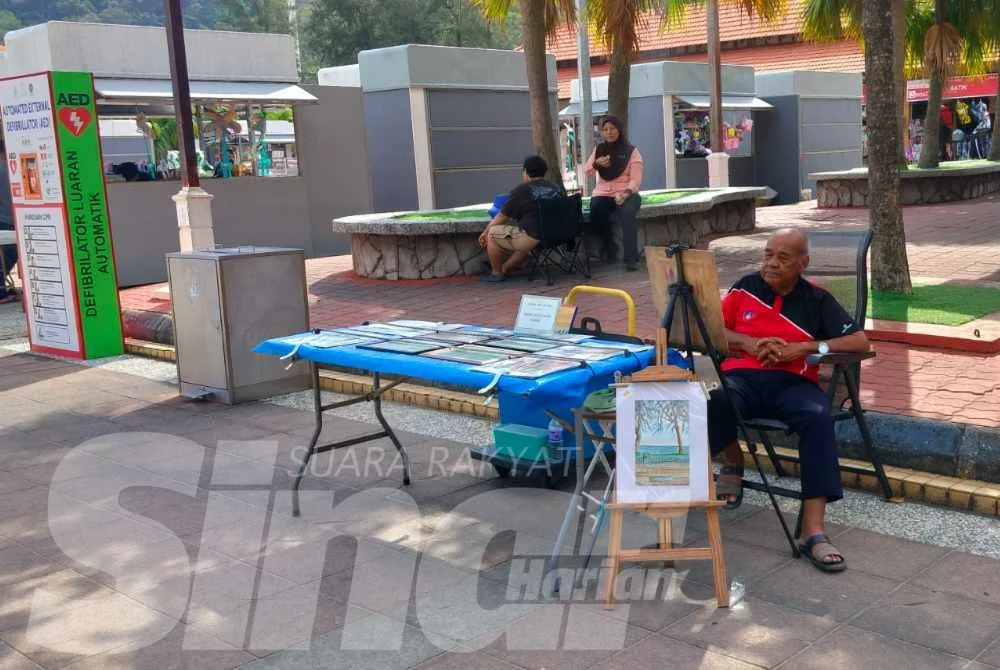 Md Noh sabar menunggu peminat seni lukisan di gerai lukisan miliknya.