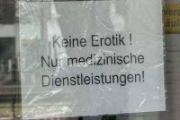 Papan tanda pada pintu kedai yang tertulis dalam bahasa Jerman iaitu 'Tiada perkhidmatan erotik, hanya perkhidmatan perubatan' di premis berkenaan. 