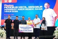 Manndzri (empat dari kanan) menyerahkan simbolik peruntukkan sebanyak RM11.53 juta kepada wakil pekebun kecil pada program Pekebun Kecil Makmur peringkat negeri di Dewan Serbaguna Taman Kota Jaya, Kota Tinggi pada Sabtu.