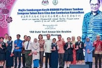 Kor Ming (enam dari kanan) mengiringi Anwar bergambar bersama pelajar pada Majlis Sumbangan Kasih Madani Parlimen Tambun Sempena Tahun Baharu Cina dan Sambutan Ramadan di Dewan Tang Ying See, Sekolah Menengah Jenis Kebangsaan Yuk Choy, pada Sabtu. Foto Bernama
