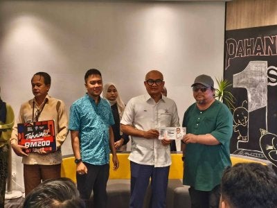 Pengerusi Jawatankuasa Komunikasi, Multimedia, Belia, Sukan negeri Pahang, Fadzli Mohamad Kamal menyampaikan hadiah kepada salah seorang penerima ketika Majlis Penyampaian Hadiah Karya Anak Pahang pada bulan November dan Disember 2025.