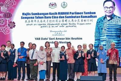Anwar Ibrahim bergambar bersama pelajar pada Majlis Sumbangan Kasih Madani Parlimen Tambun Sempena Tahun Baharu Cina dan Sambutan Ramadan di Dewan Tang Ying See, Sekolah Menengah Jenis Kebangsaan Yuk Choy, Ipoh pada Sabtu. 