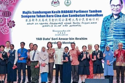 Kor Ming (enam dari kanan) mengiringi Anwar bergambar bersama pelajar pada Majlis Sumbangan Kasih Madani Parlimen Tambun Sempena Tahun Baharu Cina dan Sambutan Ramadan di Dewan Tang Ying See, Sekolah Menengah Jenis Kebangsaan Yuk Choy, pada Sabtu. Foto Bernama
