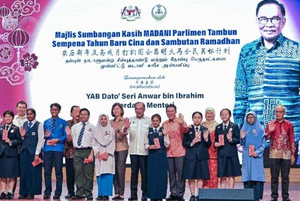 Anwar Ibrahim bergambar bersama pelajar pada Majlis Sumbangan Kasih Madani Parlimen Tambun Sempena Tahun Baharu Cina dan Sambutan Ramadan di Dewan Tang Ying See, Sekolah Menengah Jenis Kebangsaan Yuk Choy, Ipoh pada Sabtu. 